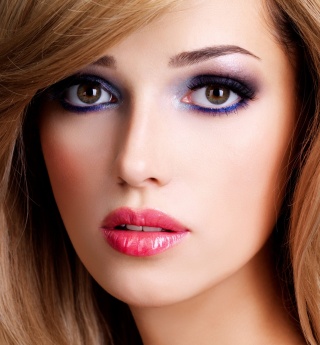 Closeup portrait of a beautiful young woman with long white hairs and red lips. Fashion model posing at studio over black background